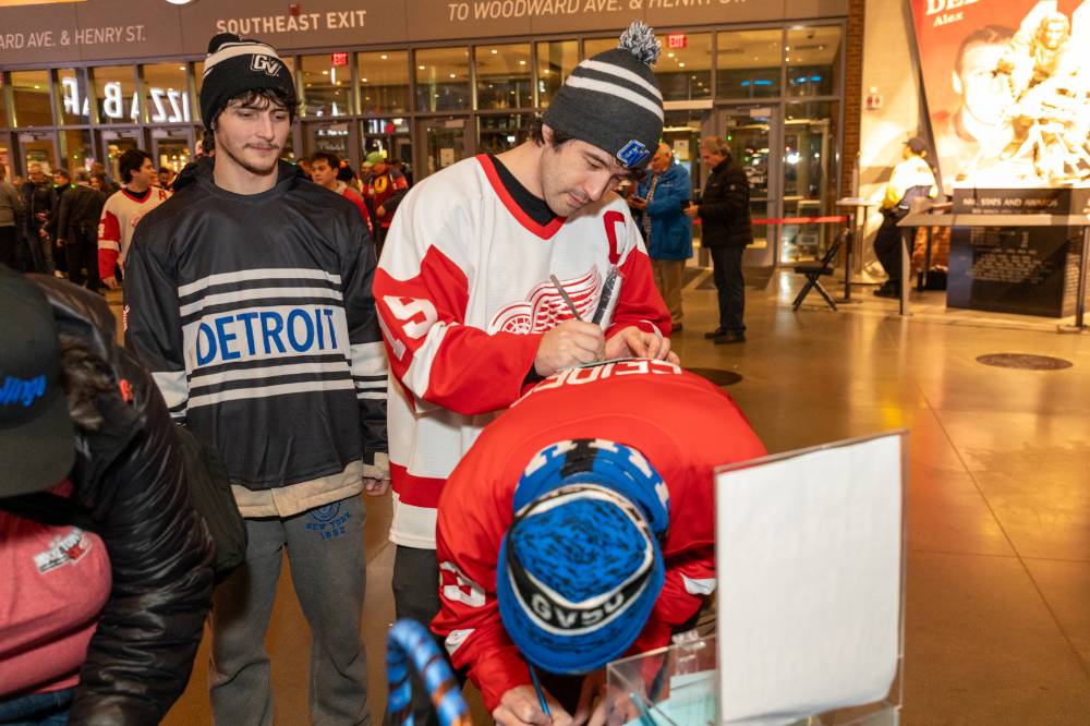 An alum writing on another alums back.